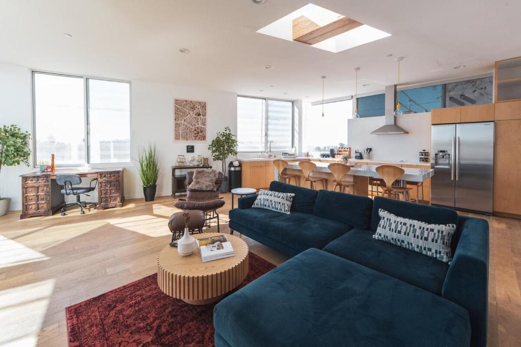 ein Wohnzimmer mit einer blauen Couch und einer Küche in der Unterkunft Industrial&Stylish 3 bedroom 3 bathrooms Home With Views and Hot tub in Los Angeles