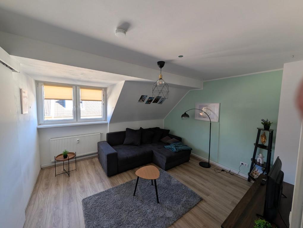 a living room with a couch and a table at Traumwohnung über den Dächern Rüttenscheids in Essen