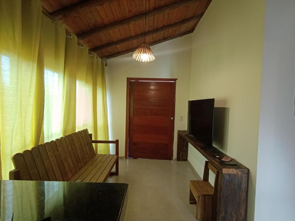 a living room with a couch and a television at Casa Xandó in Porto Seguro