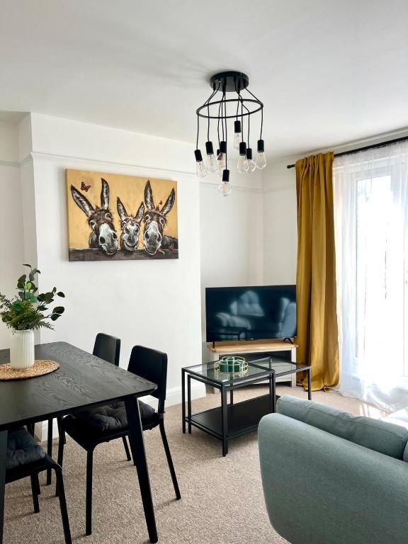 a living room with a couch and a table at Spacious 4-Bed Home Near Cambridge City Centre in CBG