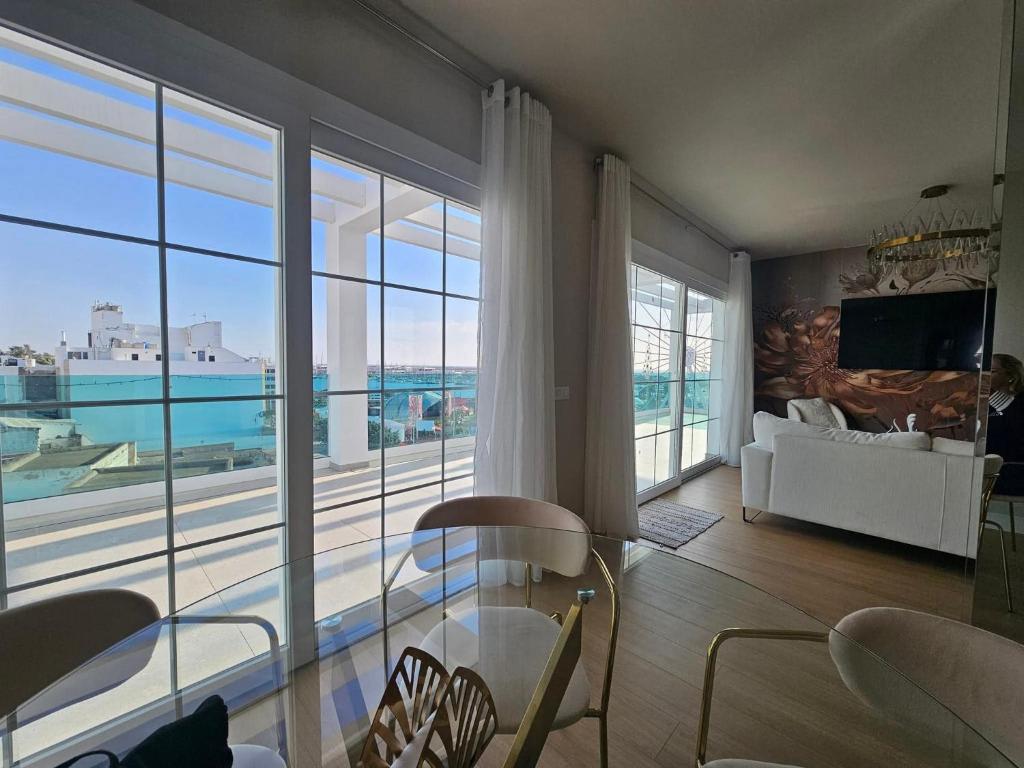 a living room with a table and a large window at Ático Monarca II in Arrecife