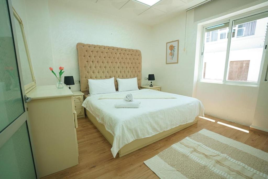 丹吉尔Cosy & Central, your Perfect City Spot的卧室里有一张白色的大床，还有一扇大窗户