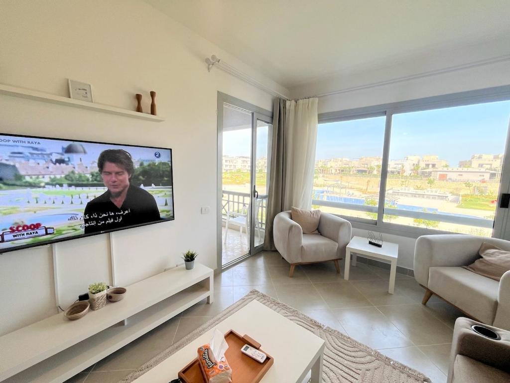 a living room with a flat screen tv on a wall at 1BDR chalet on direct swimming pool Einbay in Ain Sokhna