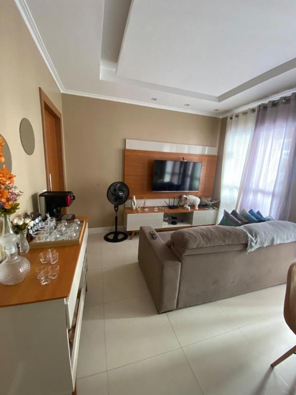 een woonkamer met een bank en een televisie bij Cop30 Apartmento in Belém