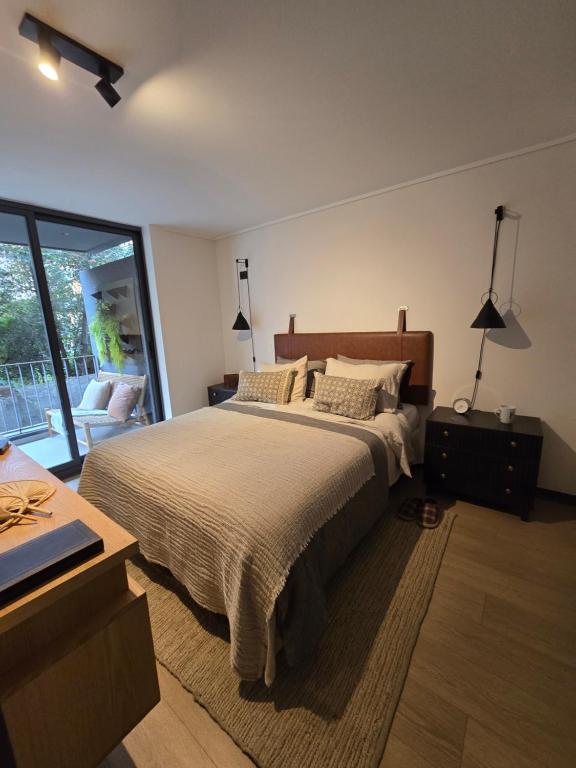 Un dormitorio con una cama y un escritorio y una ventana. en Barrio Italia Hermoso Departamento mas Parcking Gratis y Wifi, en Santiago