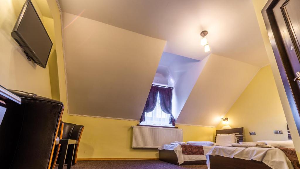 a room with two beds and a tv at Vila Hermannstadt Inn in Sibiu