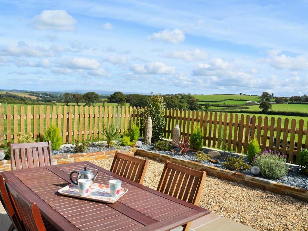 Werringtonにある3 Bed in Yeolmbridge 41848の柵のある庭にある木製のテーブルと椅子
