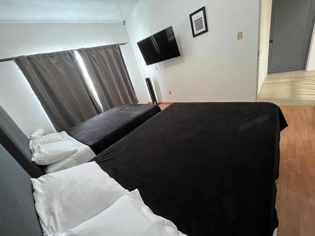 a bedroom with two beds with black and white sheets at 23 Habitación doble cama in Miravalle