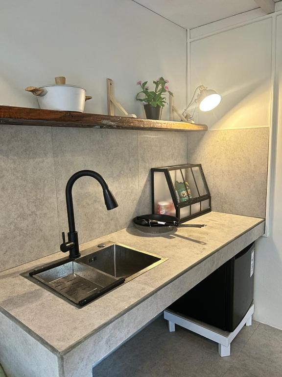 a kitchen counter with a sink and a counter top at Kawoeng kabin in Panjadakan
