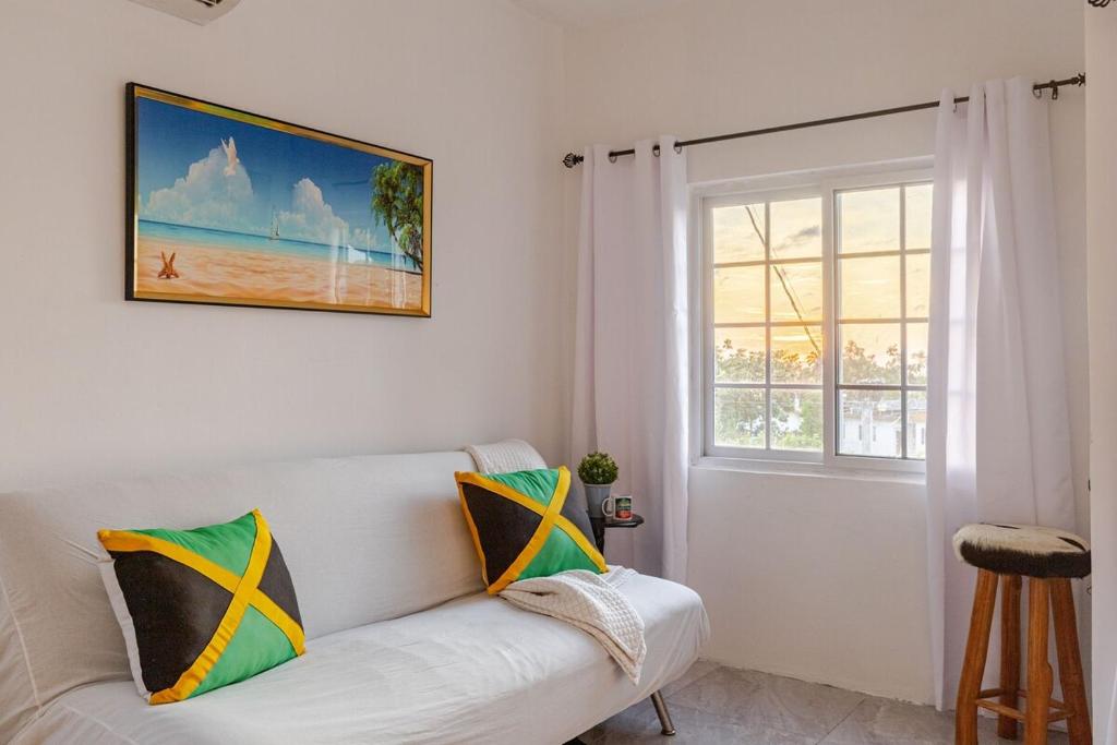 a living room with a white couch and a window at Free Shuttle & Cruise Sexy Roof Top Pool Ocean View in Negril