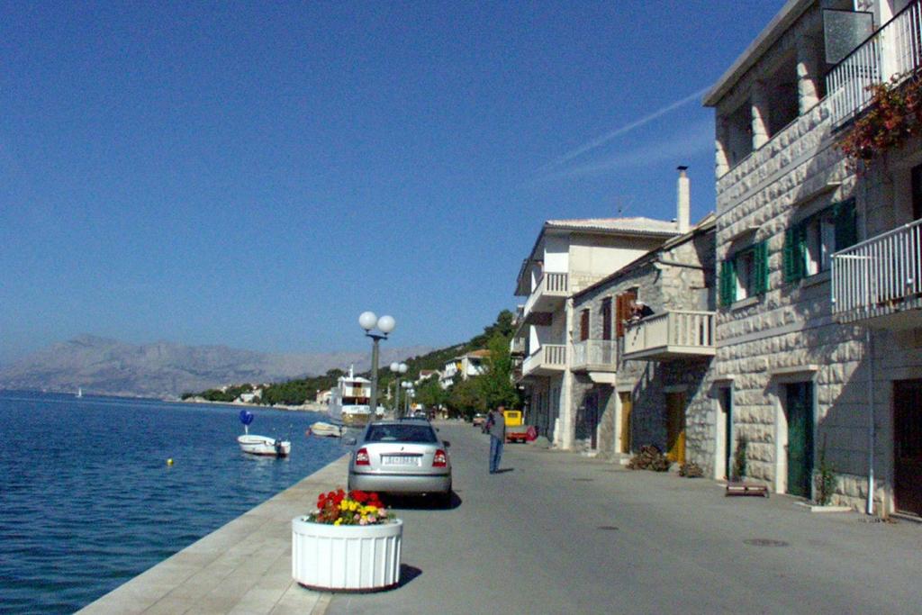 a car parked on a street next to a body of water at Apartments by the sea Povlja, Brac - 710 in Povlja