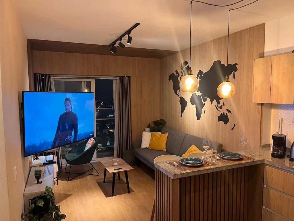 ein Wohnzimmer mit einem großen Flachbildfernseher in der Unterkunft Tempo Moderno Departamento in San Antonio