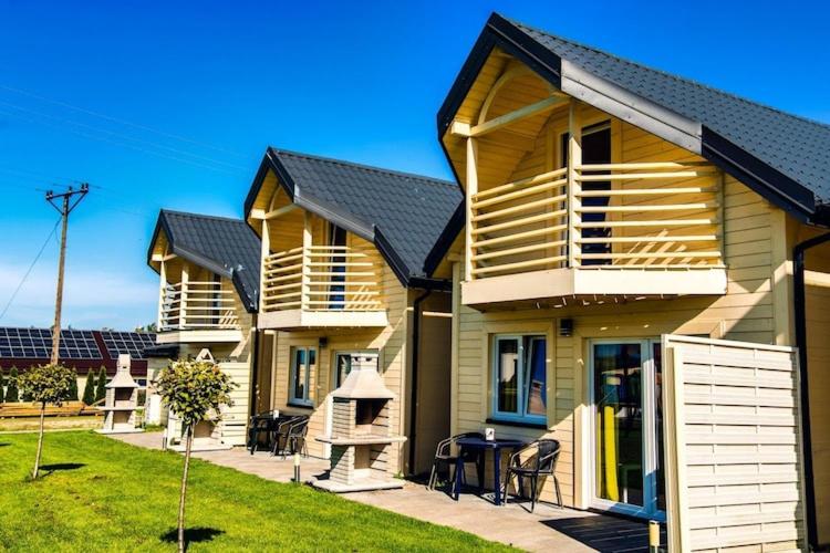 una fila di case con un prato davanti di Comfortable holiday homes with a pool a Ustronie Morskie