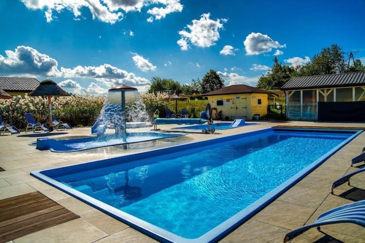 a swimming pool with a fountain in a yard at Comfortable holiday homes with a pool in Ustronie Morskie