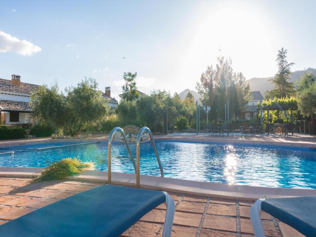 a swimming pool with two chairs in front of it at Pet-friendly Home with Swimming Pool in Cuenca