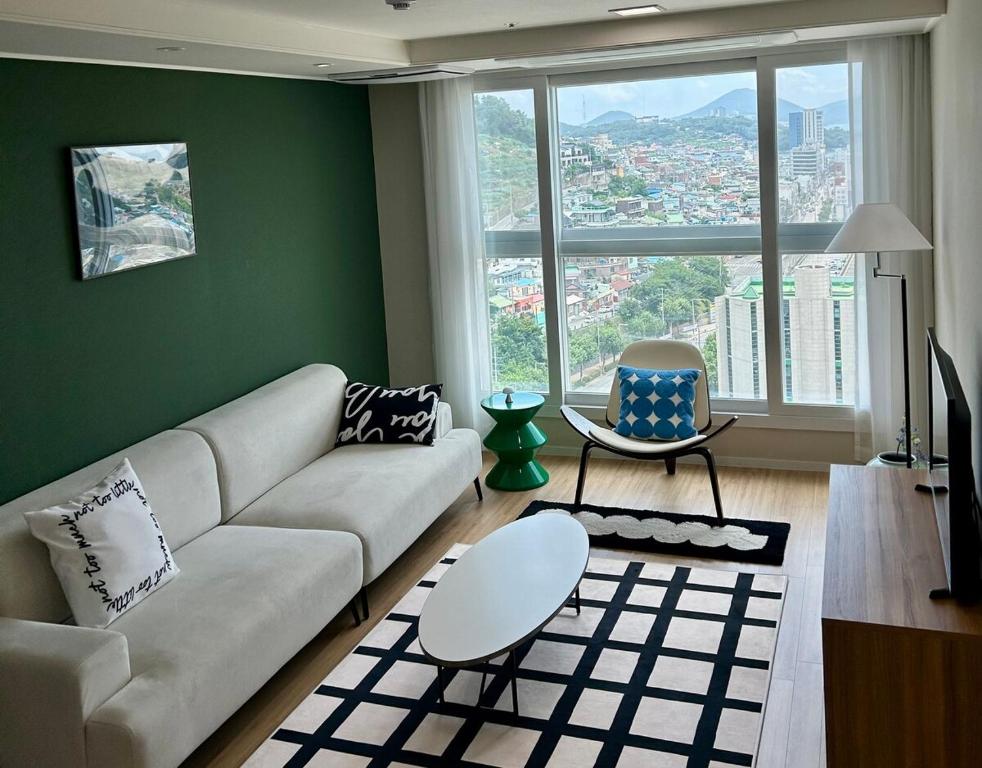 a living room with a couch and a large window at YEOSU Night Sea, Hotel Bedding in Wagol