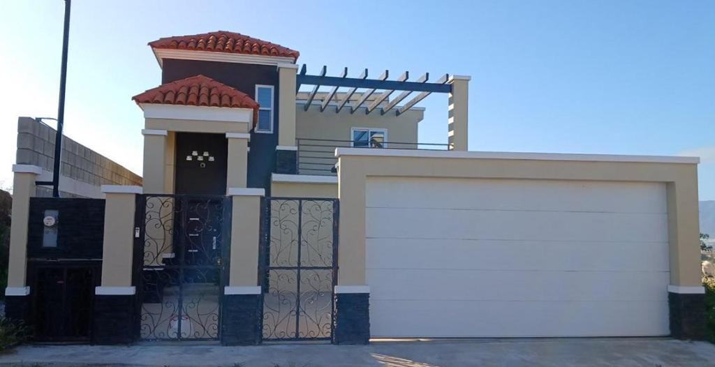 una porta bianca del garage di fronte a una casa di Vista Al Mar a Ensenada