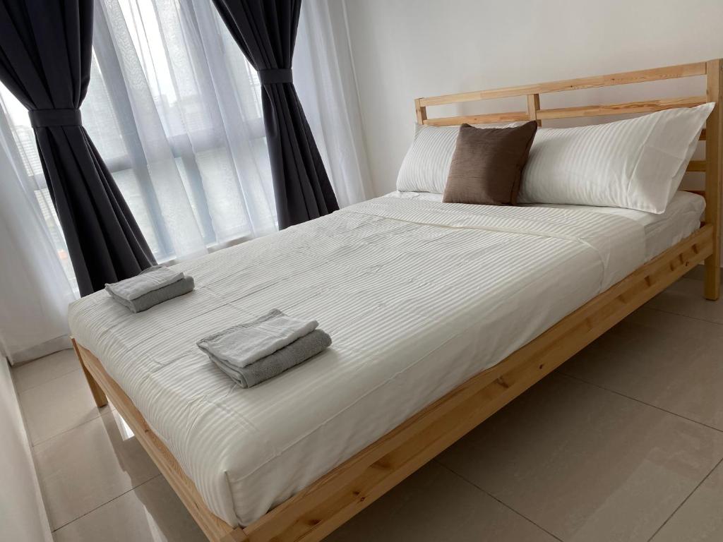 1 cama con 2 almohadas frente a una ventana en Skyhomes KLCC New, en Kuala Lumpur