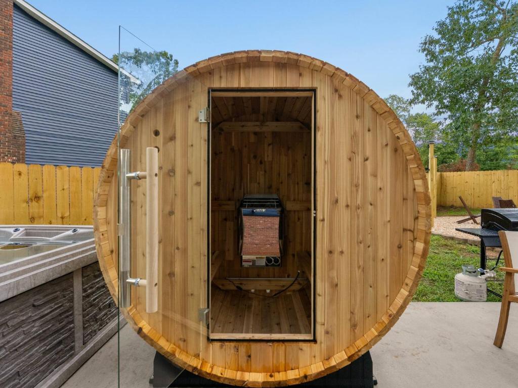 a wooden sauna with a wooden door in a yard at Fine Design | 14 Guest | Sauna | HotTub | Firepit in Southern Shops