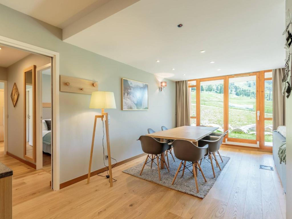 a dining room with a table and chairs at Superbe 4 pièces moyen pour 6 pers. avec piscine, spa, fitness, parking couvert, ski aux pieds - FR-1-352-68 in Arc 1800