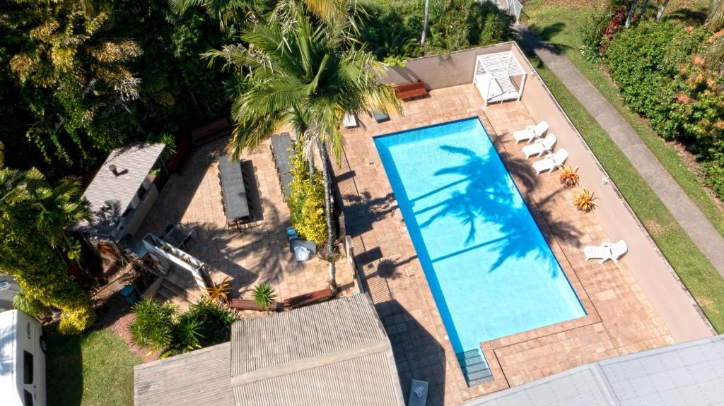 Una vista aérea de una piscina en un patio trasero. en Tropical Hibiscus Caravan Park, en Mission Beach