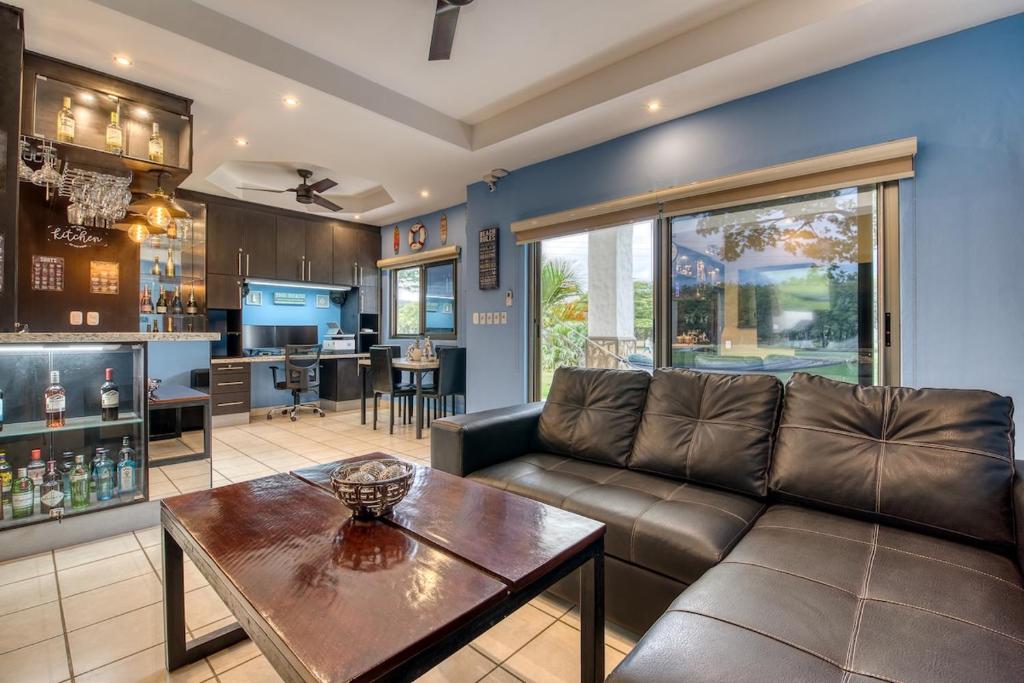 a living room with a couch and a table at Hacienda Iguana Luxury Apartment with Pool & Golf in Tola