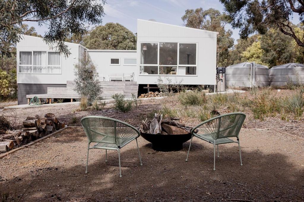 two chairs sitting in front of a house at Spring Beach Rise in Spring Beach