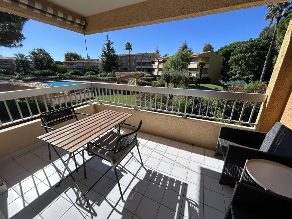 eine Terrasse mit Tisch und Stühlen auf einem Balkon in der Unterkunft Studio rénové pour 2 personnes au Lavandou avec parking - FR-1-251-871 in Le Lavandou