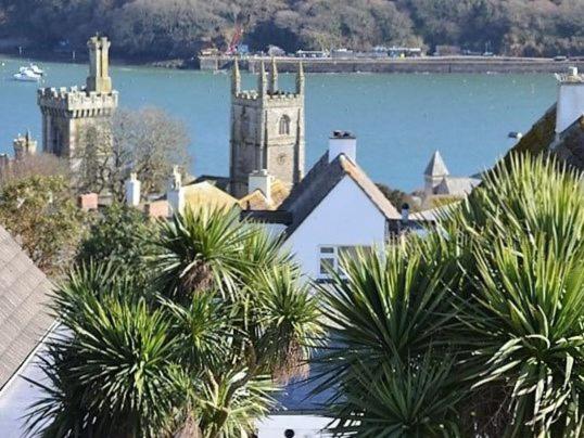 a building with a tower and a church with a body of water at Riverview in Fowey