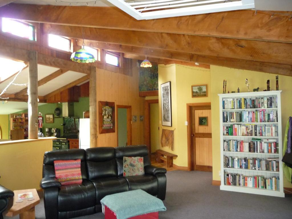 a living room with a couch and a book shelf at Lovely rural 3 bedroom home near the Kahurangi NP 