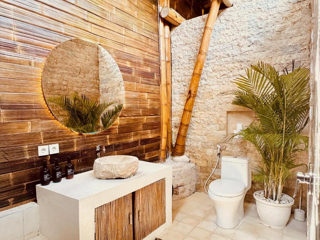 ウルワツにあるCasa Bamboo uluwatu 2の洗面台、トイレ、鏡のあるバスルーム