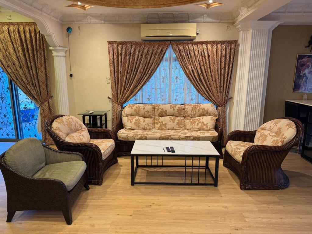 a living room with a couch and two chairs and a table at Kas Villa Homestay JB in Johor Bahru