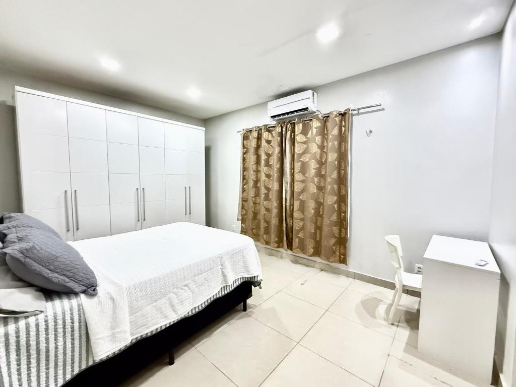 a white bedroom with a bed and a shower at Casa da Anita in Boa Vista