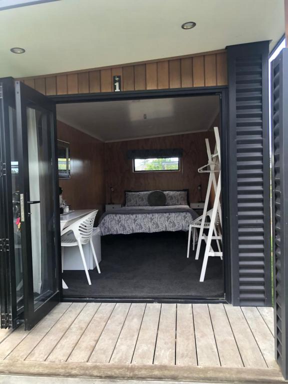 ヘイスティングズにあるA Rural Retreat, Cabin with Private Bathroom No 2のベッド、テーブル、デスクが備わる客室です。