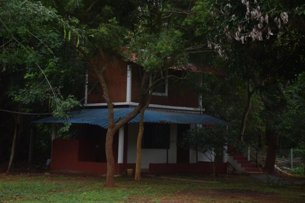 a red and white house with a blue roof at Purity Stay by Crib Community in Auroville