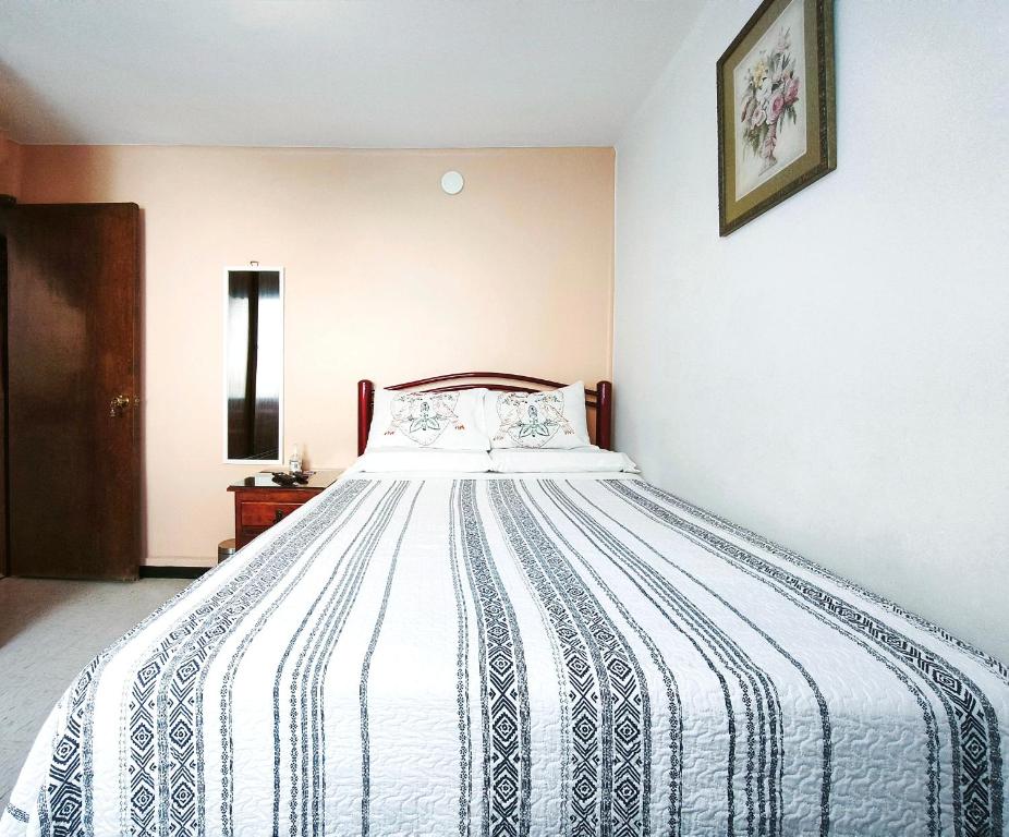 a bedroom with a bed with a blue and white comforter at Cozy bedroom at 5 min Mexico City Airport T1 & T2 in Mexico City