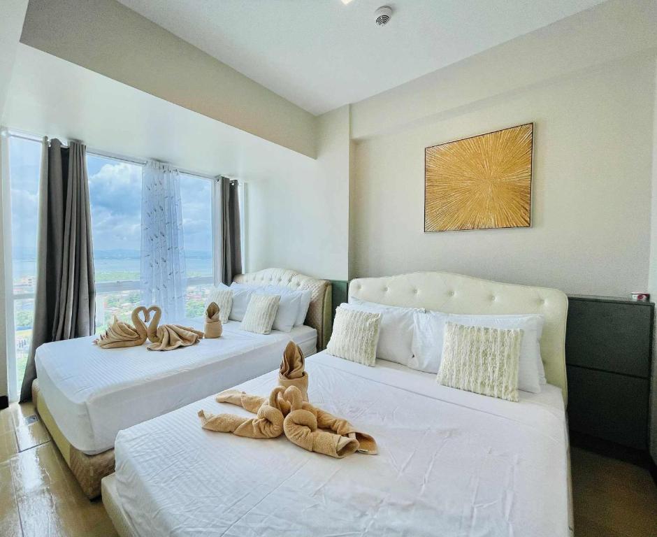 two beds with stuffed animals on them in a bedroom at Heart of Mactan Newtown big space with free wifi and pool access in Punta Engaño