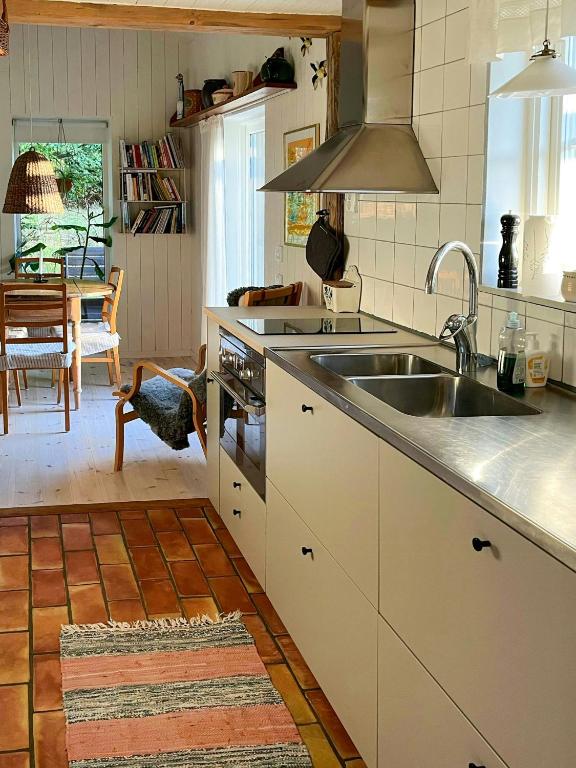 a kitchen with a sink and a stove at Sustainable Cabin In Beech Forest At Mellby Käsk in Södra Mellby