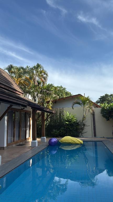 a swimming pool in front of a house at Rusto Villa in Nathon Bay