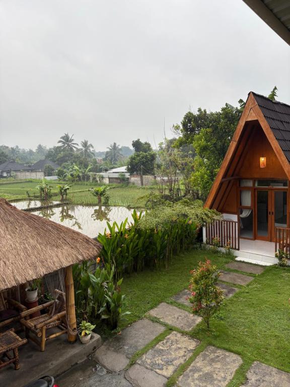 a house with a grass roof and a garden at Rinjani view bungalow in Masbagik