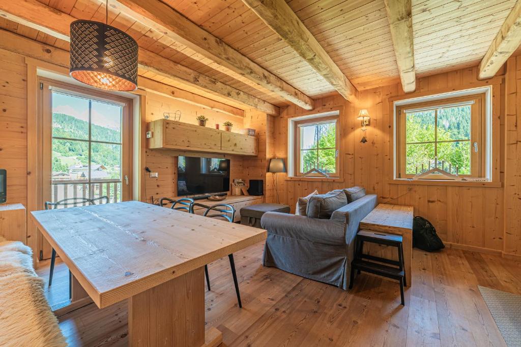 a dining room and living room in a log cabin at Alpine Heart in Falcade