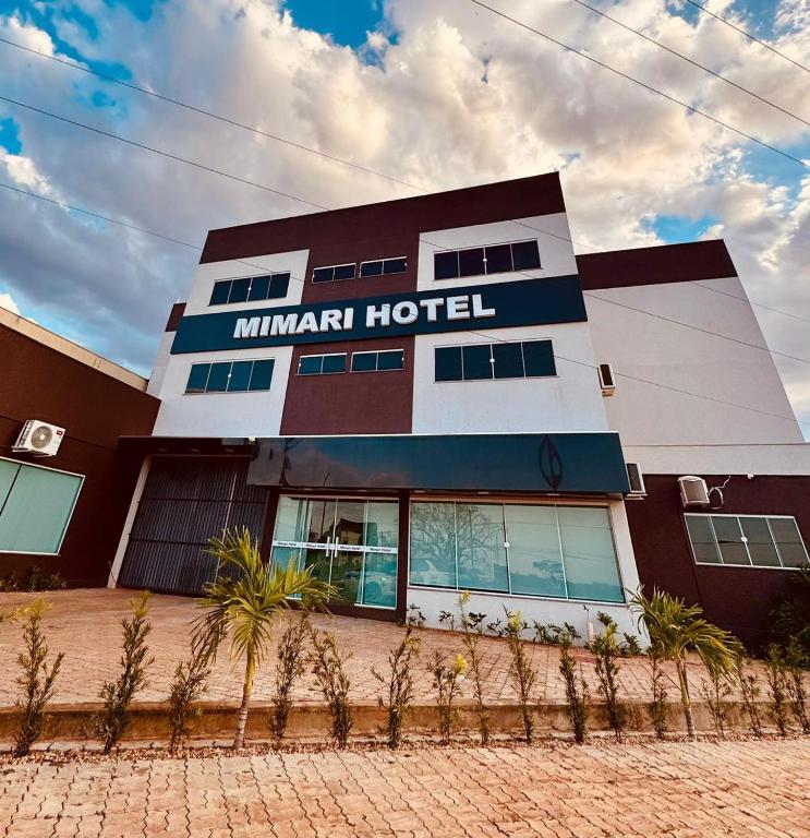 Un hotel Mahanamn con palmeras al frente. en Mimari Hotel, en Tangará da Serra