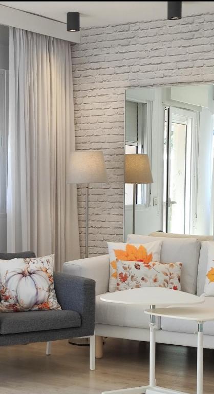a living room with a white couch and a mirror at Casa Fuerte Playa in La Herradura