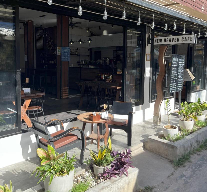 a cafe with chairs and tables in front of a building at Mari hostel in Koh Tao