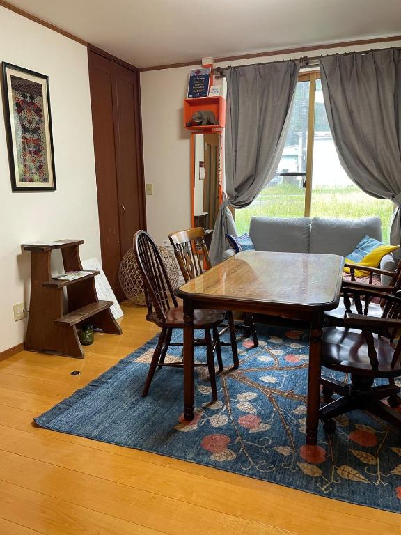 a living room with a wooden table and chairs at Akane Craft Inn in Hachinohe