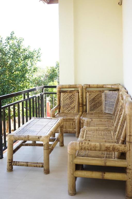 a patio with a table and a bench on a porch at Tide and Tribe hostel in Kuta Lombok