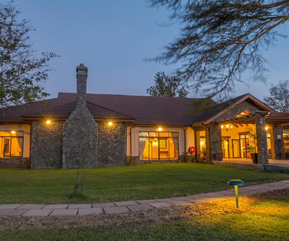 a home at night with its lights on at Sweetwaters Serena Camp in Nanyuki