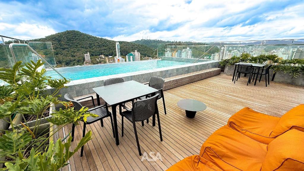 uma varanda com mesa e cadeiras e uma piscina em ASA | Loft UP 309 | Lado da FURB | Oktoberfest em Blumenau