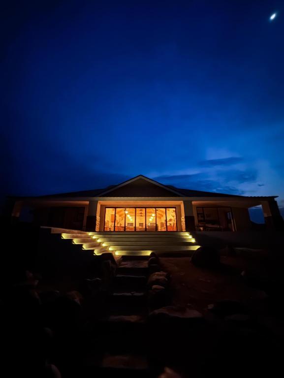 a house with lights in the window at night at Leeuwkuil Lodge in Philipstown