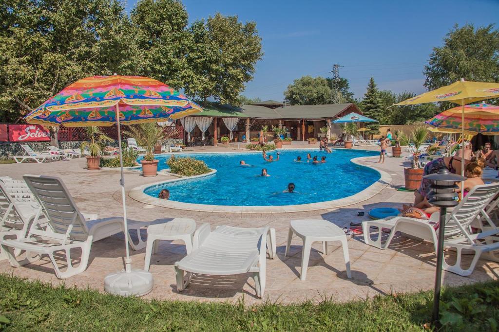 a pool with chairs and umbrellas and people in it at Hotel Kristel Park - All Inclusive Light in Kranevo